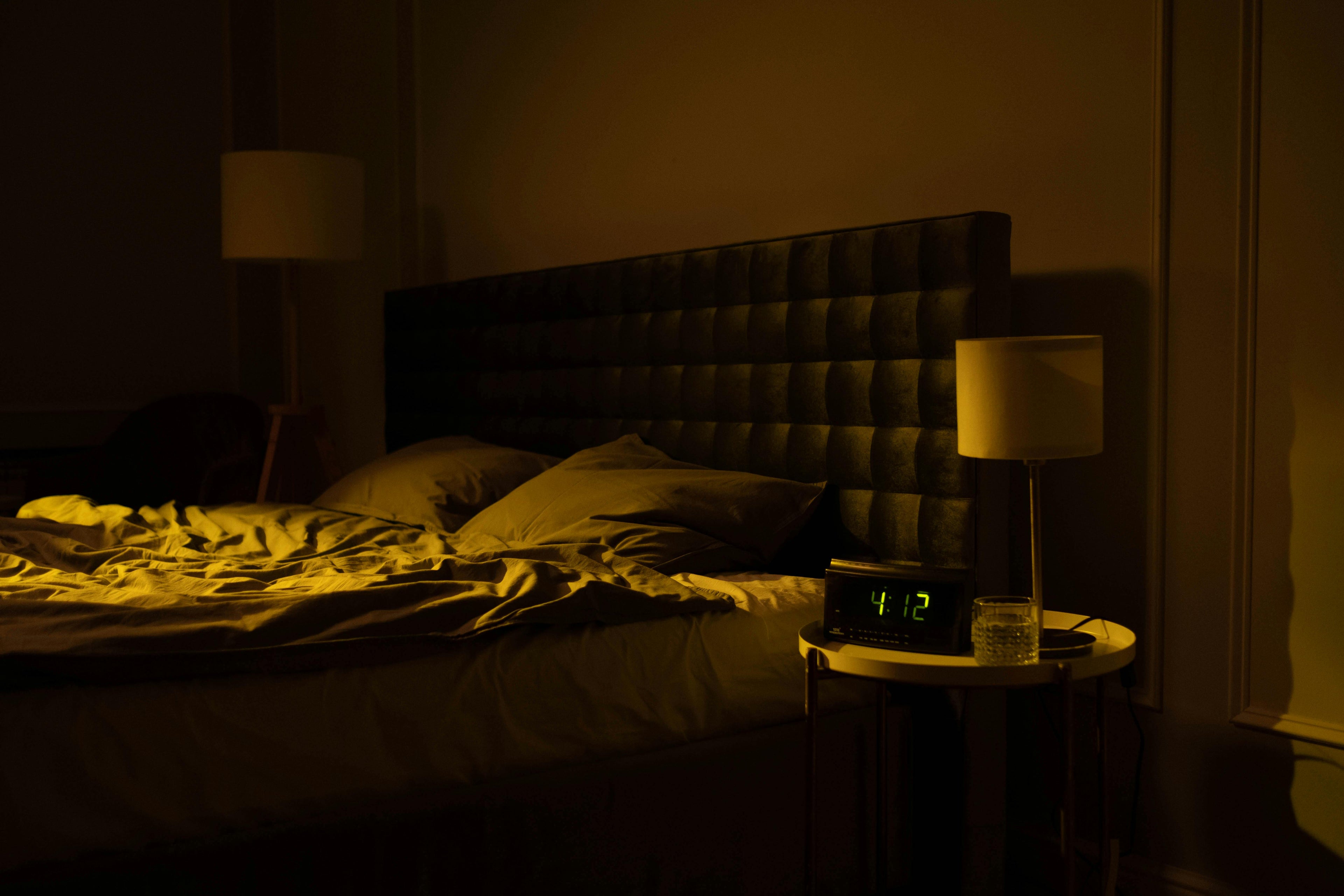 ozy modern bedroom at night with ambient lighting, digital clock reading 4:12 AM, and a soft upholstered headboard – perfect peaceful sleep space inspiration.