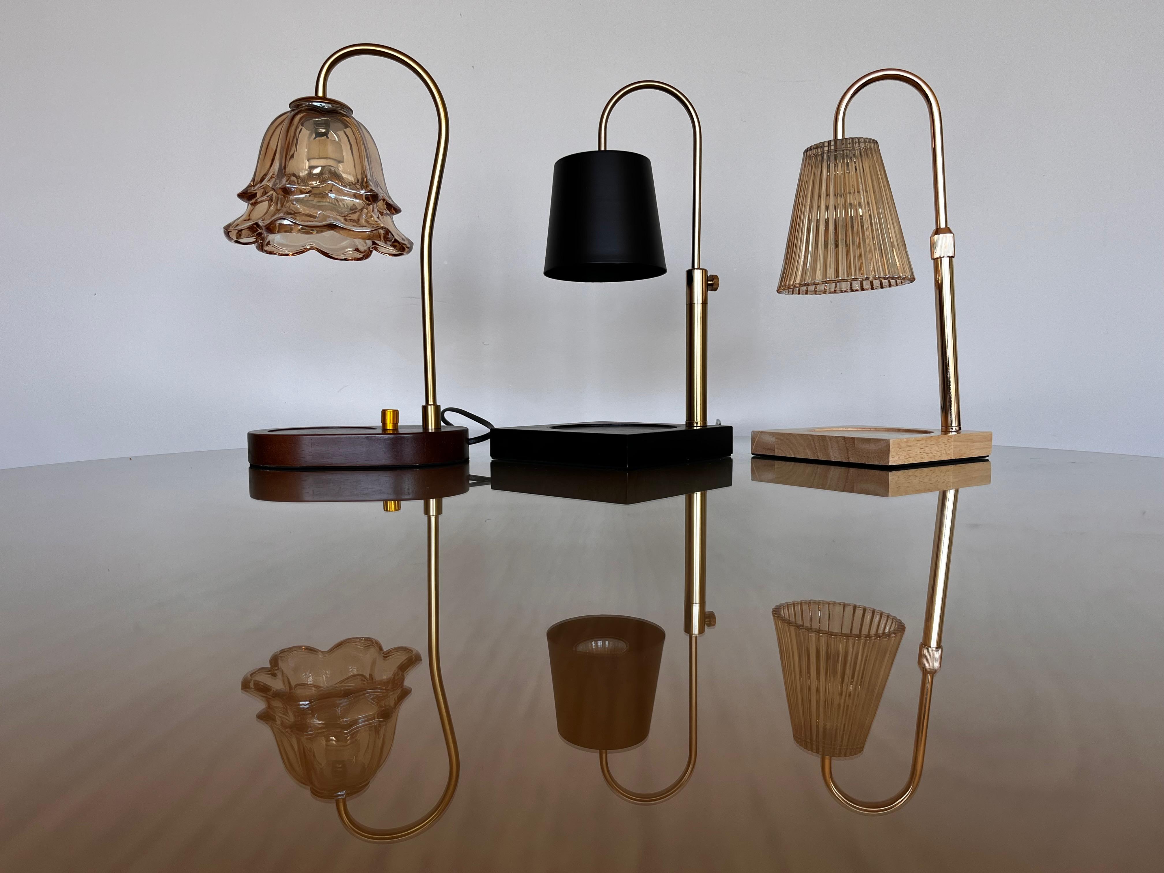 Auren Candle Warmer Collection including the Bloom, Modern and Elegance Candle warmers stand on a reflective surface.
