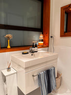  Auren Elegance Candle Warmer in a modern bathroom sink setup with soft, ambient lighting from a stylish candle warmer glowing atop the windowsill, gently warming a creamy-toned candle—creating a spa-like, calming atmosphere perfect for evening wind-down routines.